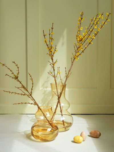 Zwei Mini-Vasen mit Zweigen mit gelben Knöpfen